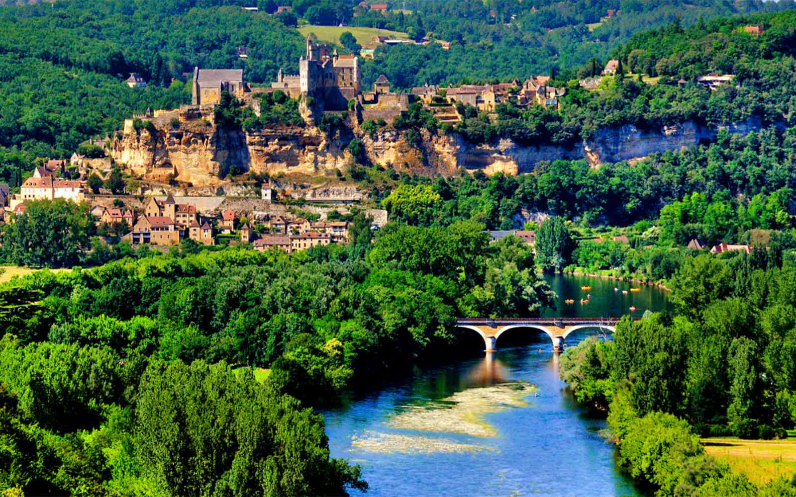 aerial view of french countryside river and stone bridge to village